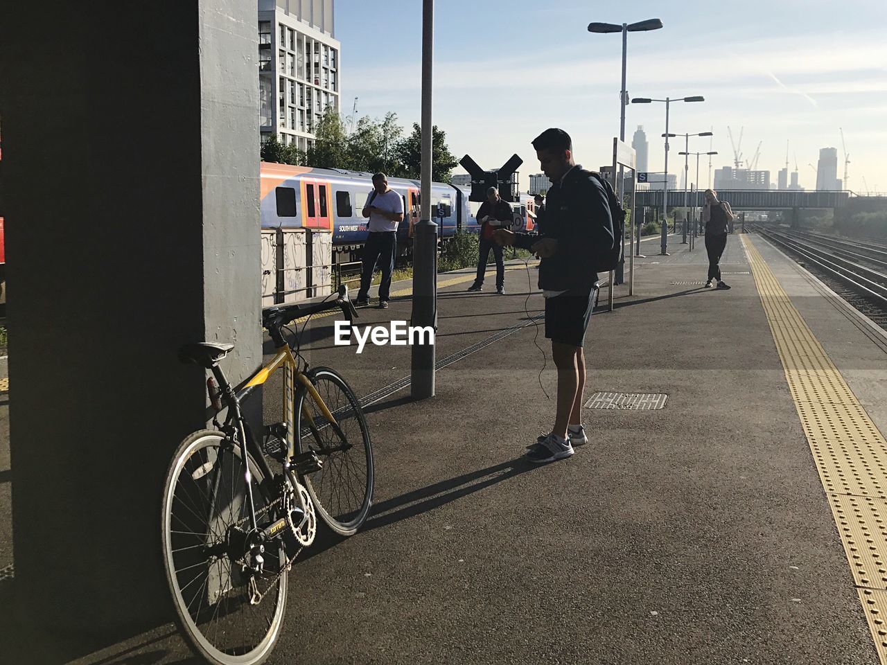 MAN CYCLING ON ROAD IN CITY