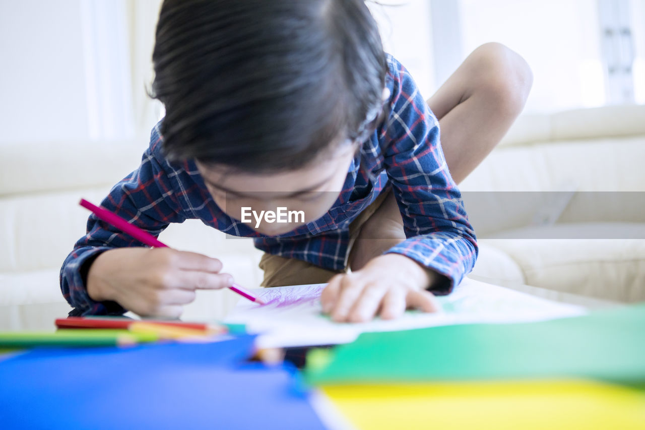 REAR VIEW OF BOY LOOKING THROUGH CAMERA