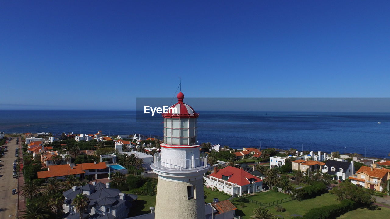 HIGH ANGLE VIEW OF SEA AND BUILDINGS AGAINST CLEAR SKY