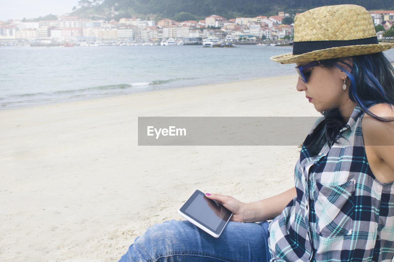 Young woman with tablet on the beach