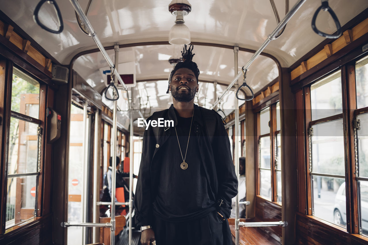 Young man standing in tram