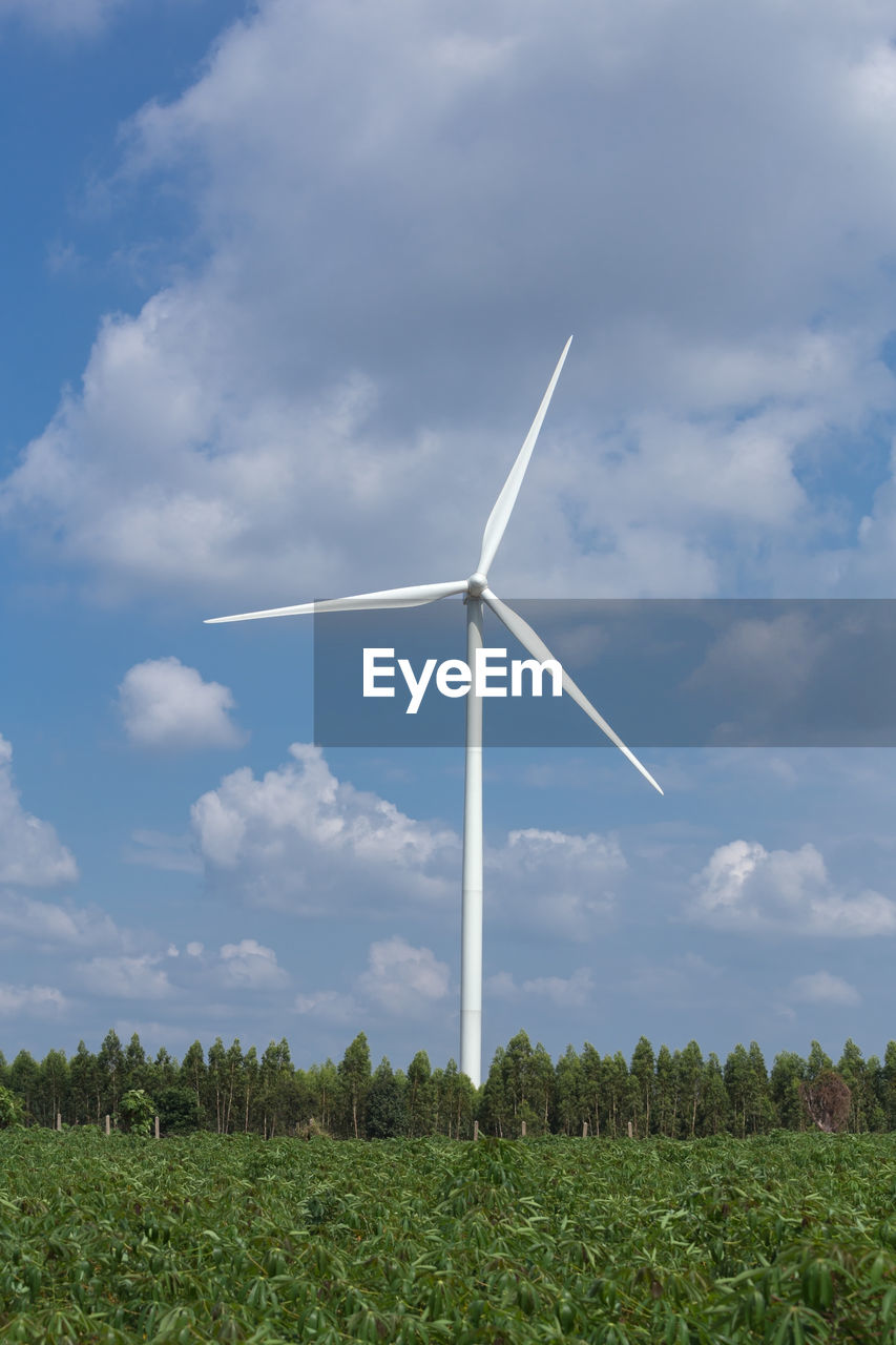 WIND TURBINE ON FIELD AGAINST SKY