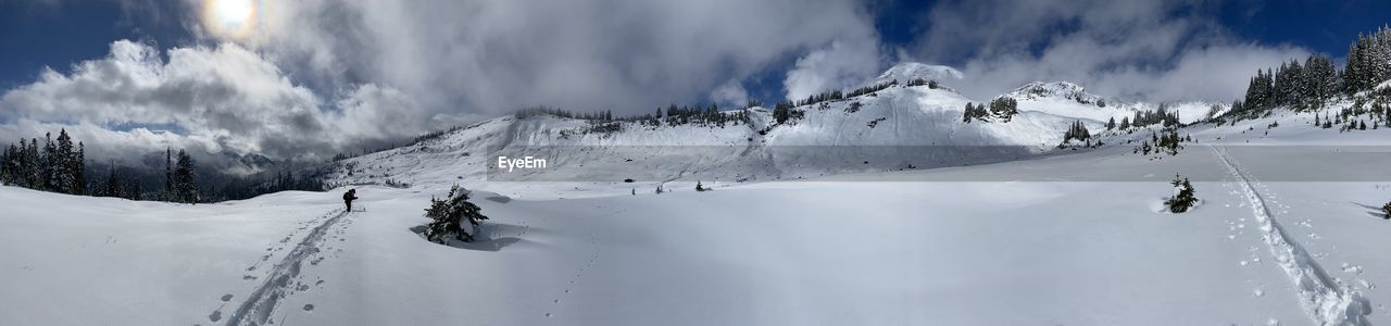 snow, cold temperature, winter, mountain, scenics - nature, environment, sports, landscape, nature, beauty in nature, winter sports, panoramic, cloud, mountain range, sky, skiing, ski equipment, tree, leisure activity, land, adventure, vacation, holiday, snowcapped mountain, travel, ski, travel destinations, trip, forest, day, plant, non-urban scene, ski touring, extreme sports, footwear, ski mountaineering, coniferous tree, outdoors, sports equipment, activity, pine tree, piste, tranquility, white, ski holiday, tranquil scene, one person, tourism, motion, pinaceae, frozen
