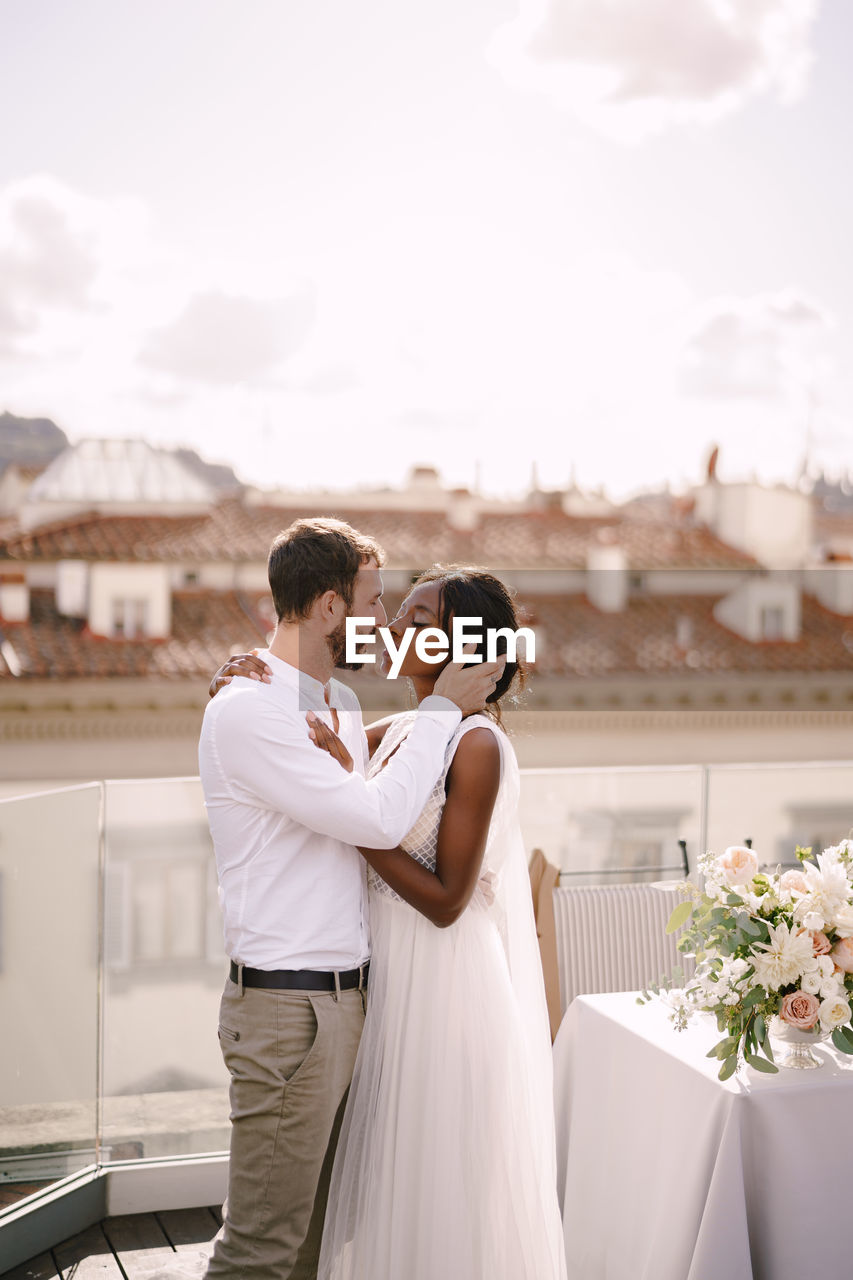 REAR VIEW OF MAN AND WOMAN HOLDING HANDS AT HOME