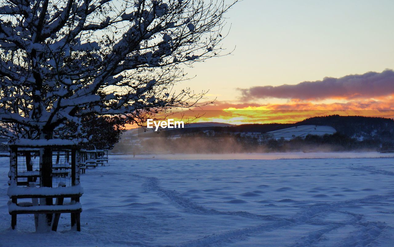SCENIC VIEW OF SNOWY LANDSCAPE AGAINST SKY DURING SUNSET