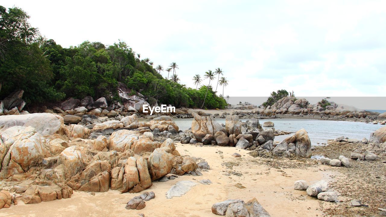 ROCKS ON SHORE AGAINST SKY