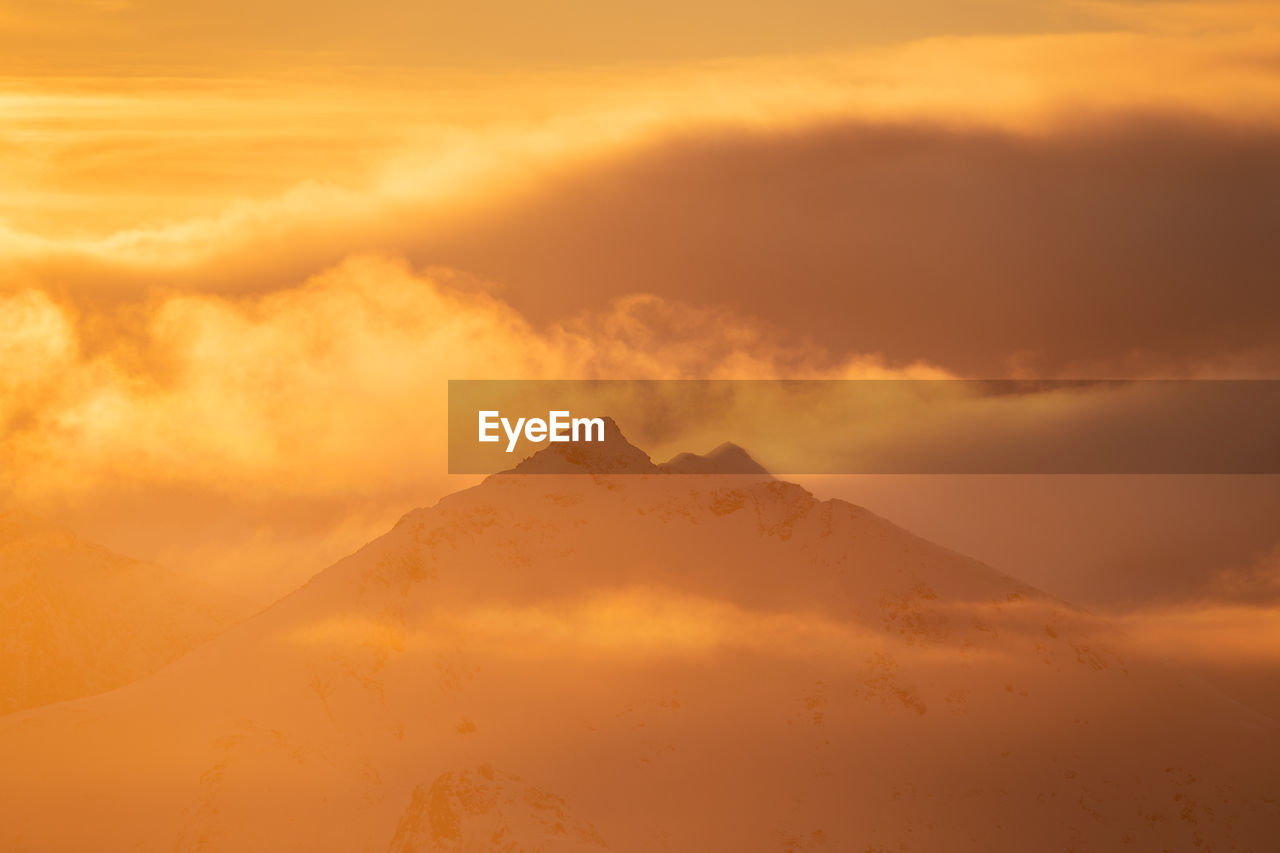 Scenic view of snowcapped mountains against sky during sunset