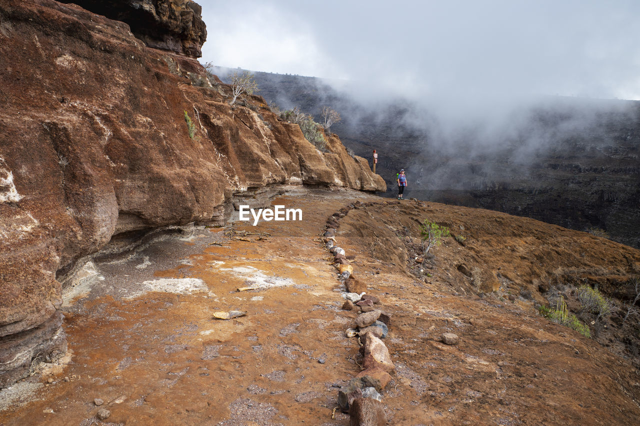 Senior woman hiking along trail in barranco de la negra