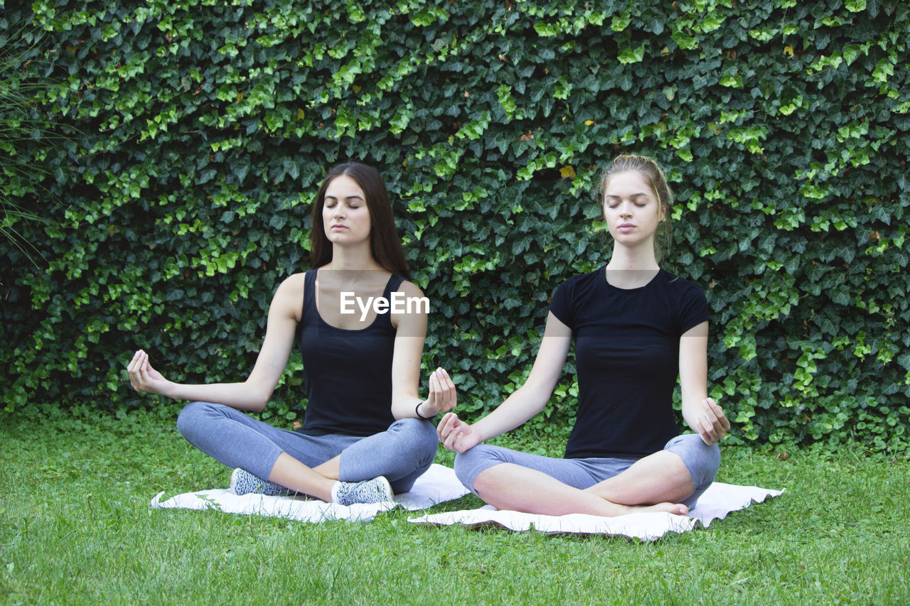 Young friends exercising in park