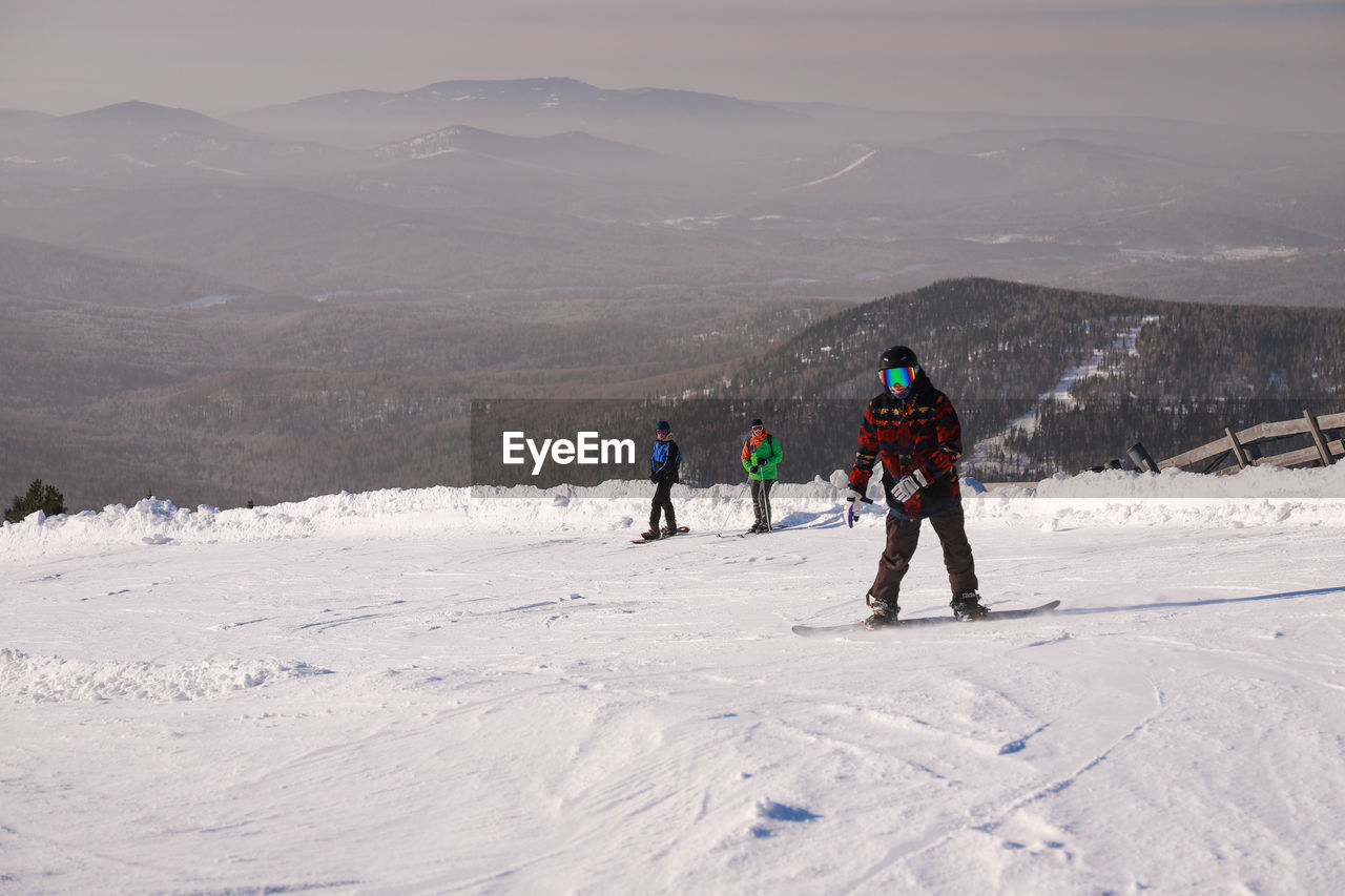 snow, mountain, winter, cold temperature, sports, mountain range, leisure activity, winter sports, adventure, skiing, environment, vacation, holiday, nature, scenics - nature, trip, beauty in nature, landscape, full length, activity, travel, men, ski touring, lifestyles, day, ski mountaineering, ski holiday, group of people, ski, piste, snowcapped mountain, non-urban scene, ski equipment, adult, clothing, travel destinations, nordic skiing, warm clothing, recreation, sports equipment, hiking, sky, footwear, land, ski-wear, extreme sports, white, tourism, outdoors, ski pole, walking, motion, togetherness, person, rear view, backpack, small group of people, tourist, frozen, women