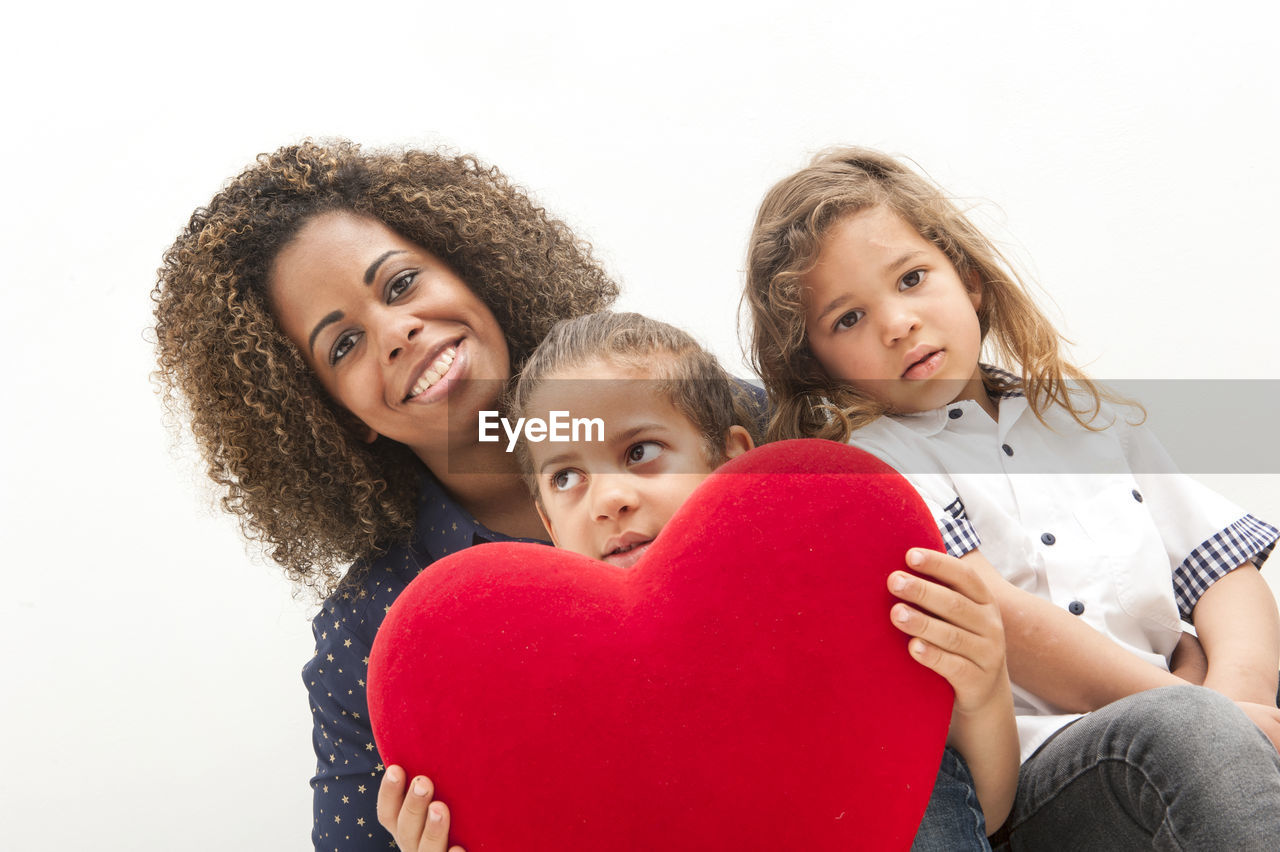 Happy brazilian mother with two children, with red heart in their hands.  mother's day