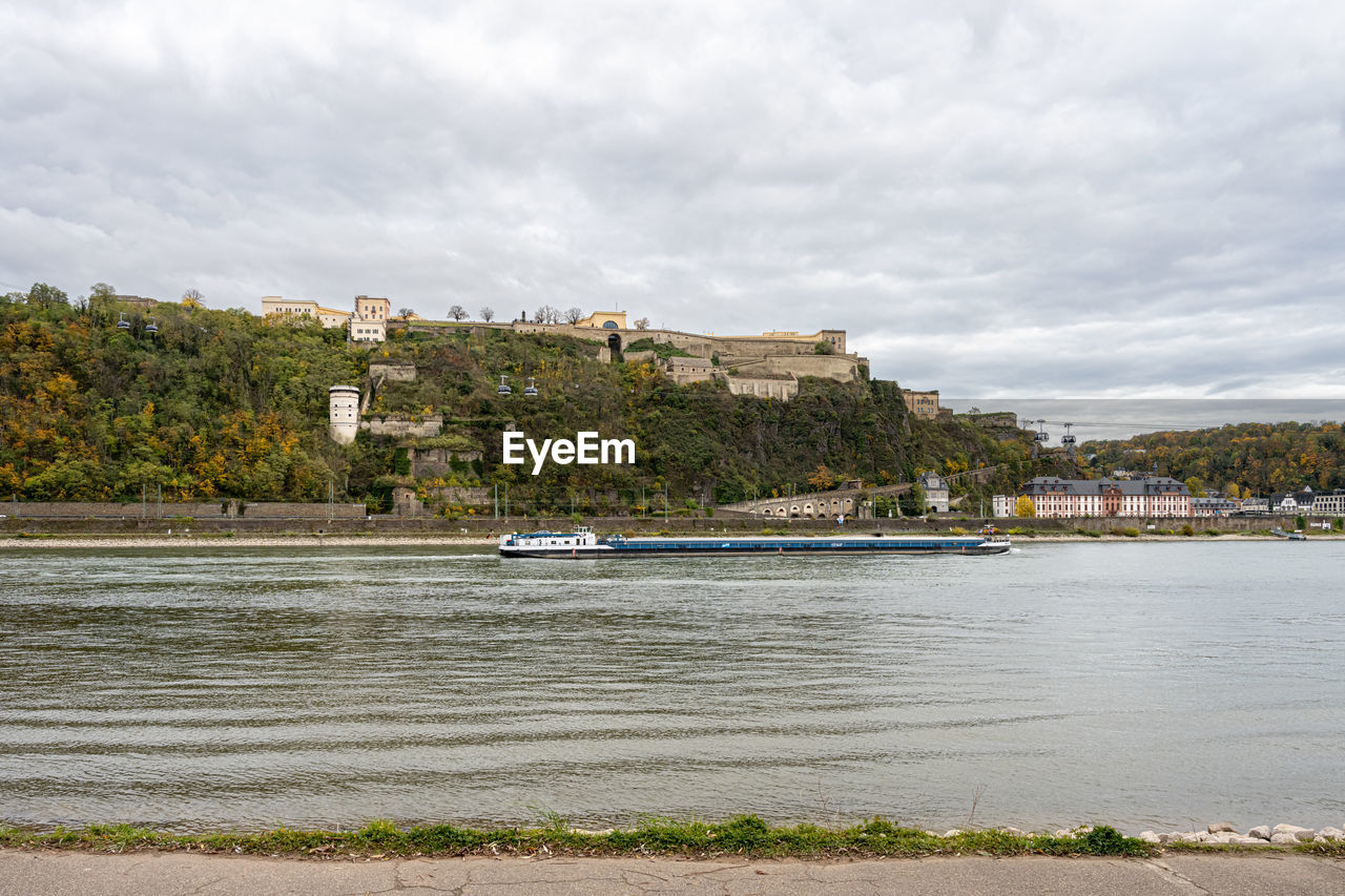 scenic view of sea by buildings against sky