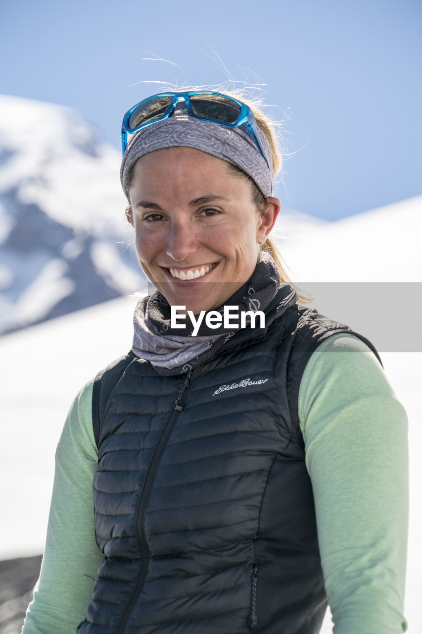 Portrait of smiling female mountaineer with mt. baker in the background