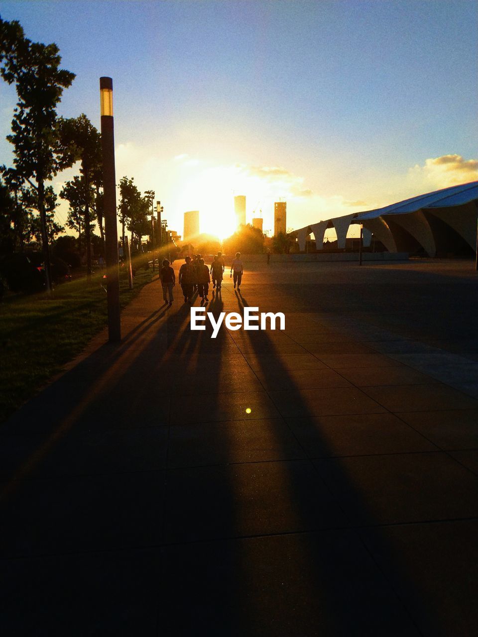 PEOPLE WALKING ON STREET AT SUNSET