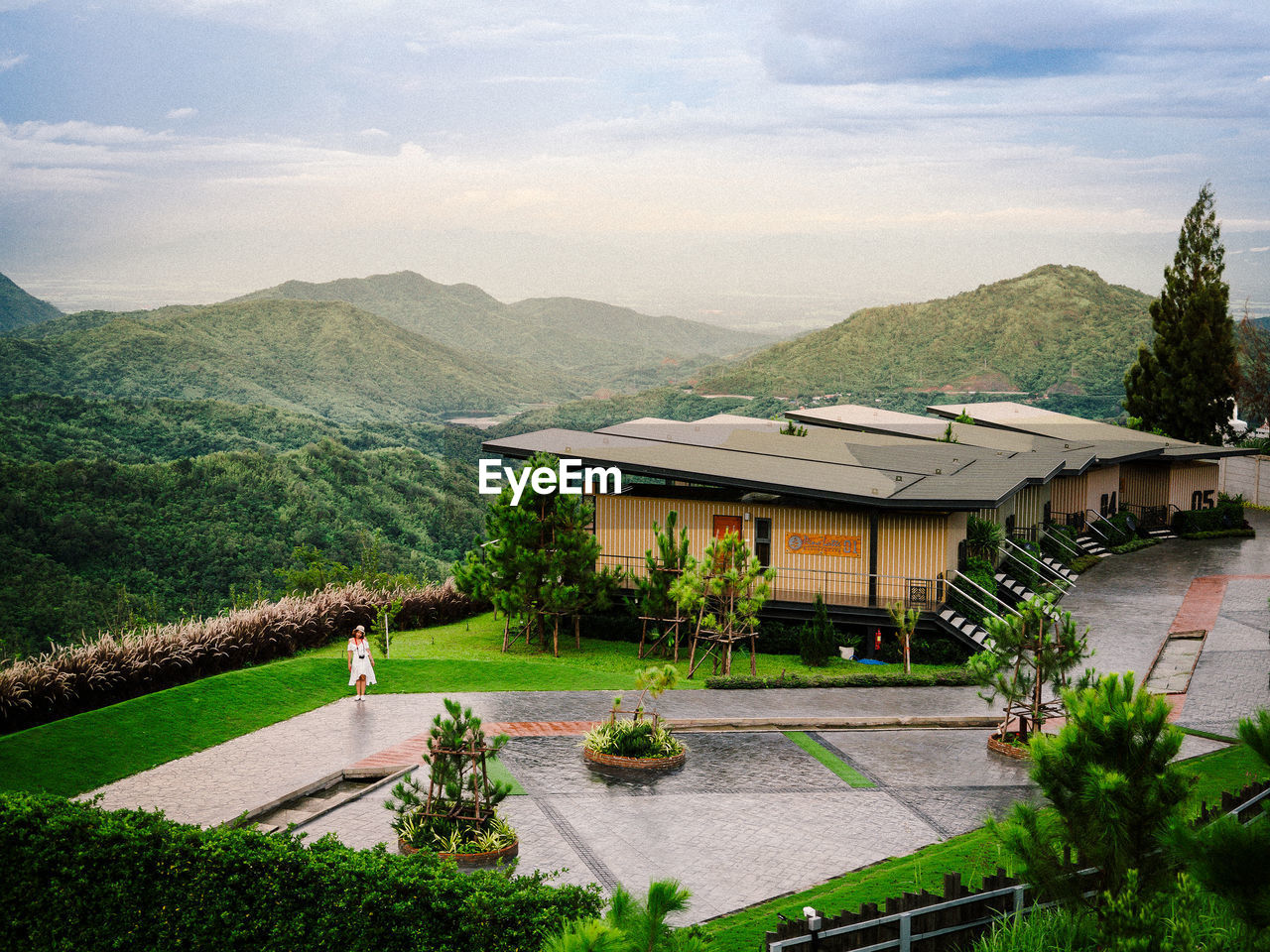 Built structure by trees and plants against sky