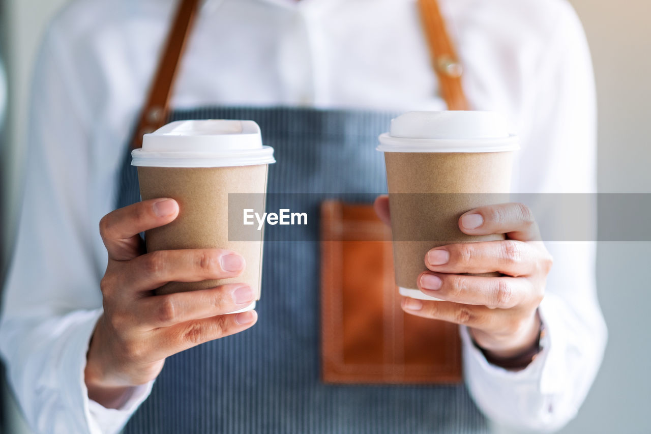 CROPPED IMAGE OF WOMAN HOLDING COFFEE