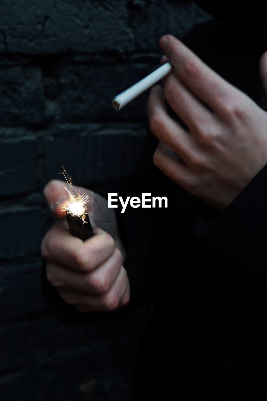 Close-up of person igniting cigarette with lighter