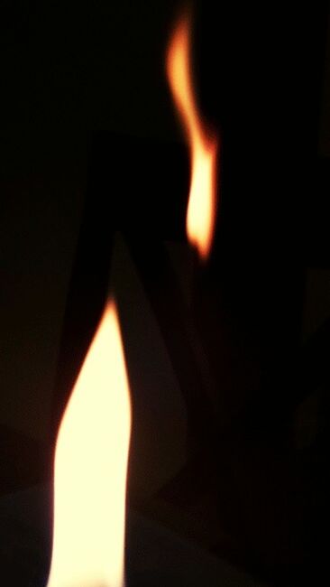 CLOSE-UP OF LIT CANDLE IN FIRE