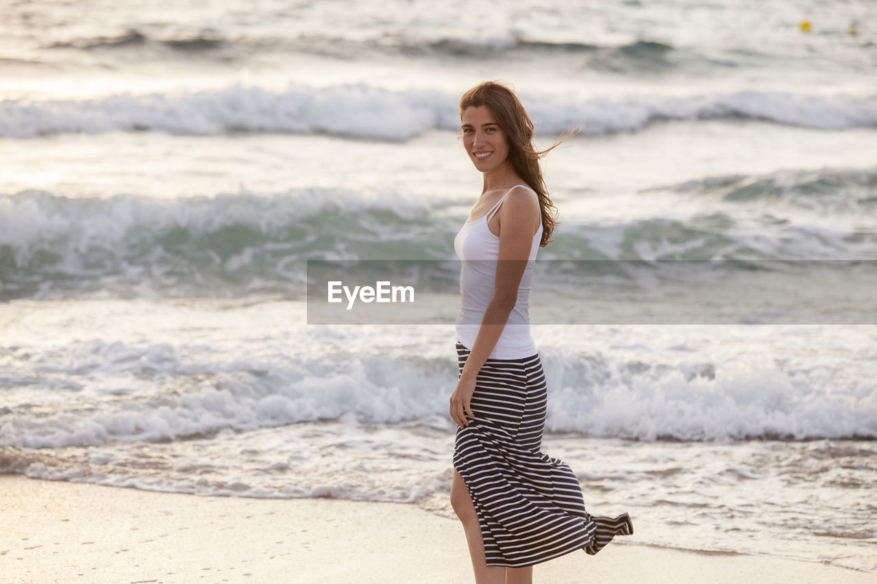 WOMAN STANDING AT BEACH