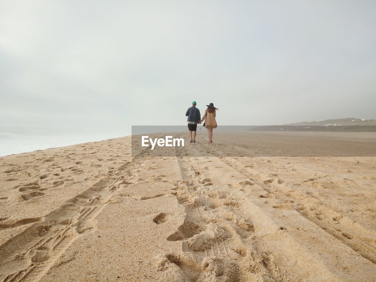 REAR VIEW OF FRIENDS WALKING ON BEACH