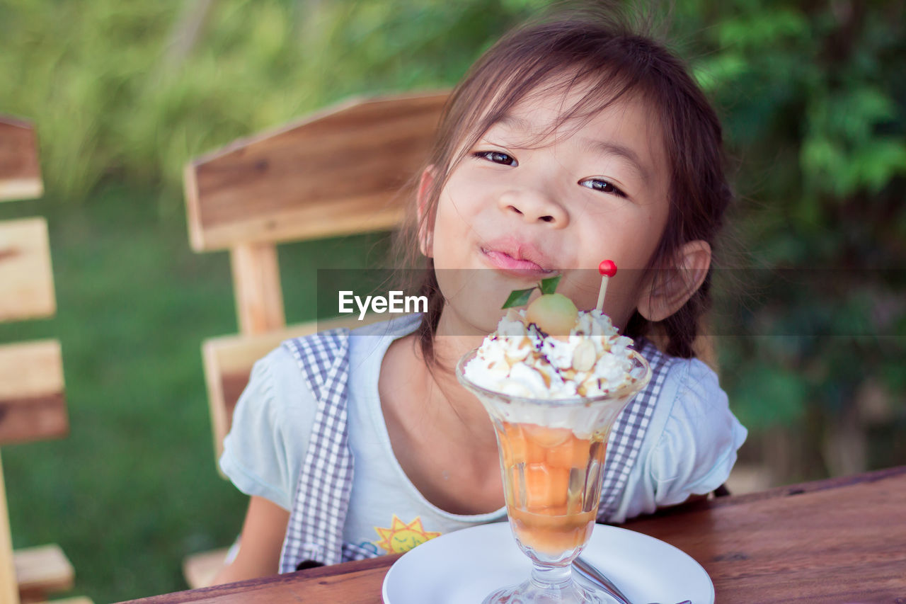 Portrait of cute girl by food on table