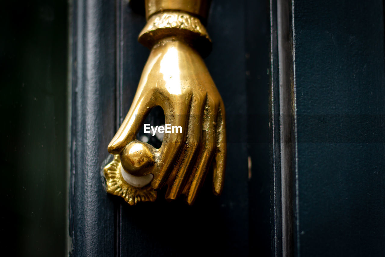 door handle, gold, door, entrance, yellow, no people, doorknob, darkness, metal, close-up, light, knob, lighting, door knocker, indoors, protection, wood, hanging, security