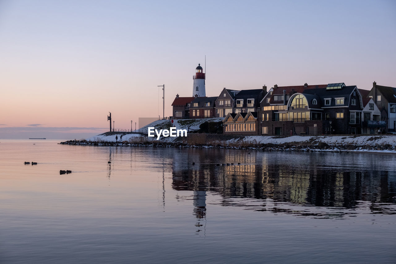 BUILDINGS BY SEA AGAINST CLEAR SKY