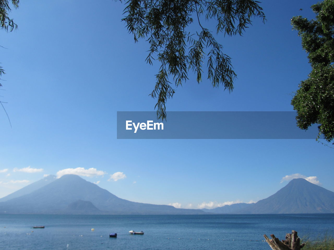 SCENIC VIEW OF SEA AND MOUNTAINS AGAINST BLUE SKY