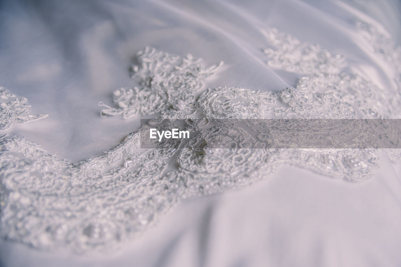 High angle view of lace on white textile