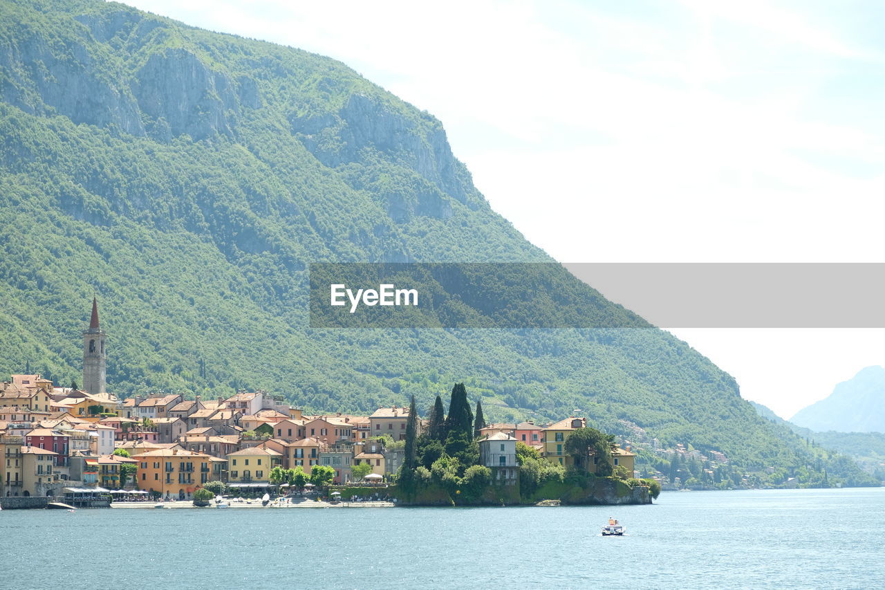 Scenic view of sea by buildings against sky