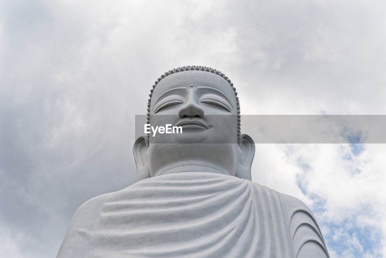 Low angle view of buddha lowtue against against sky