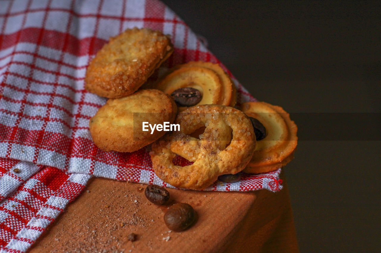 High angle view of cookies and pretzel on table in darkroom