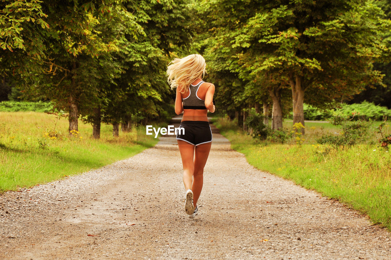 Rear view of woman running on road