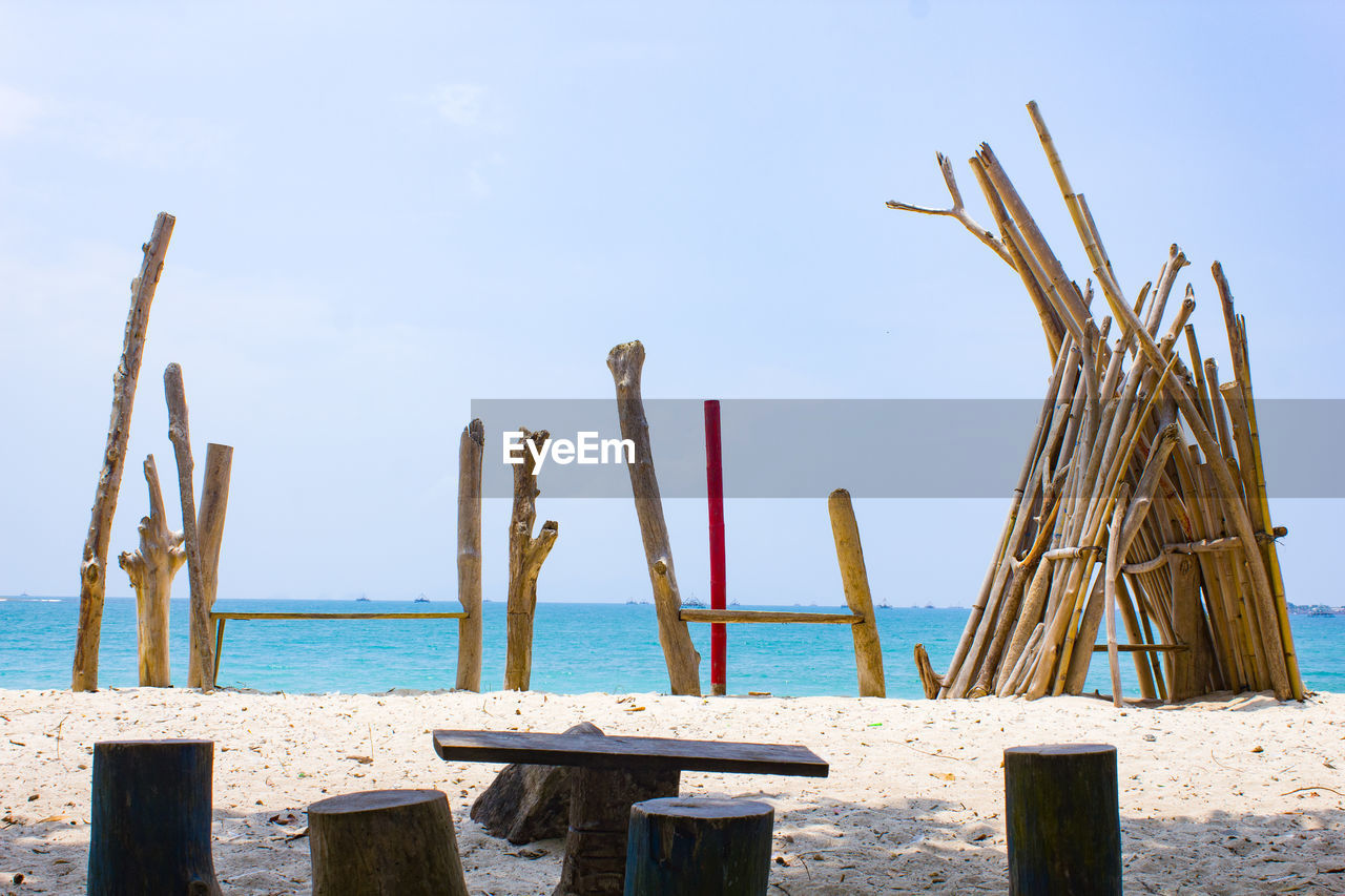 WOODEN POSTS ON BEACH