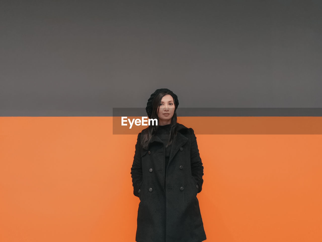 Portrait of woman standing against wall