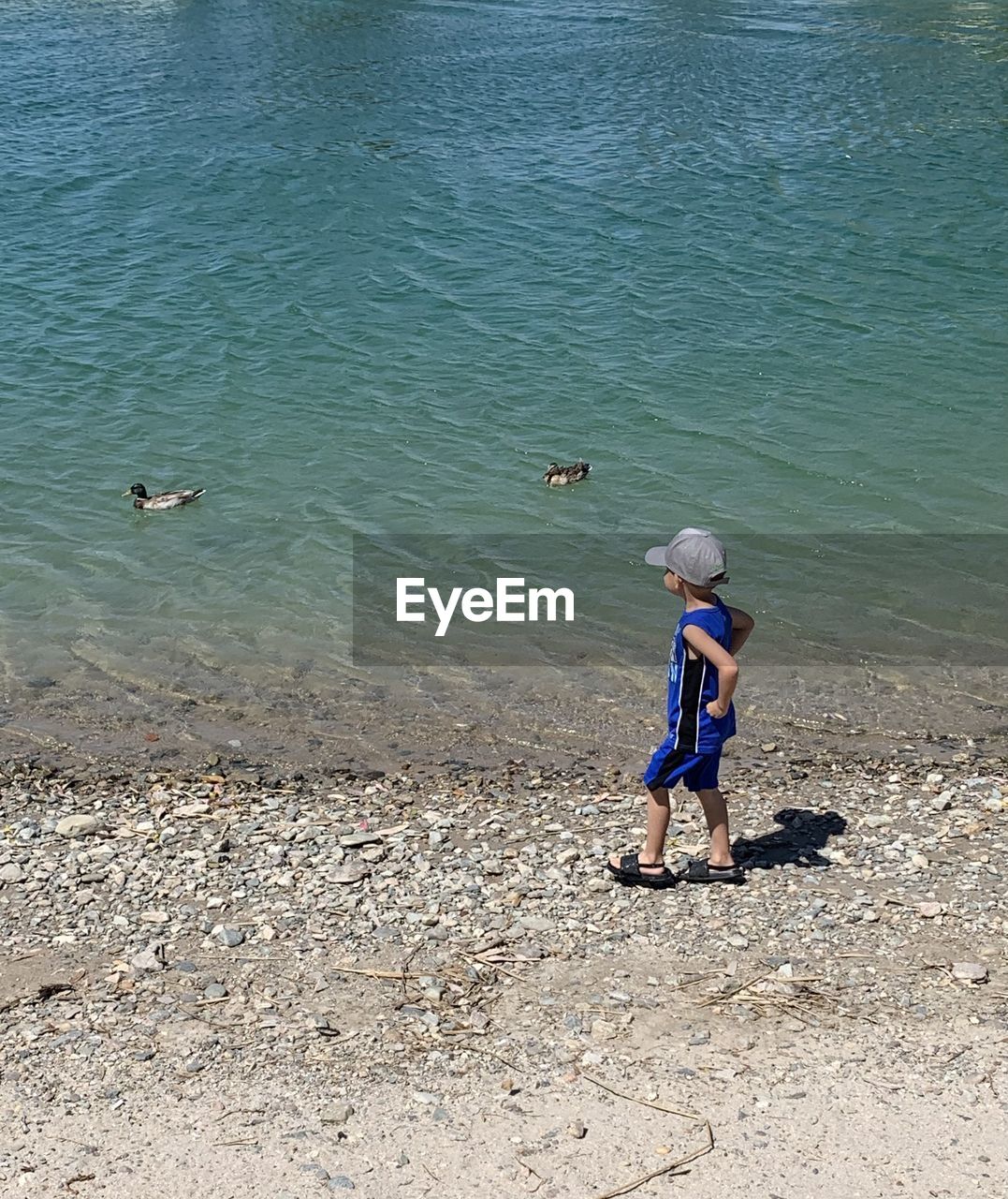 Child standing by the lake.