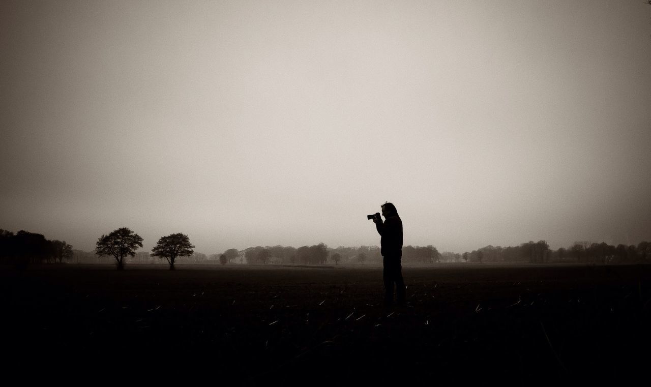 Silhouette person photographing on landscape