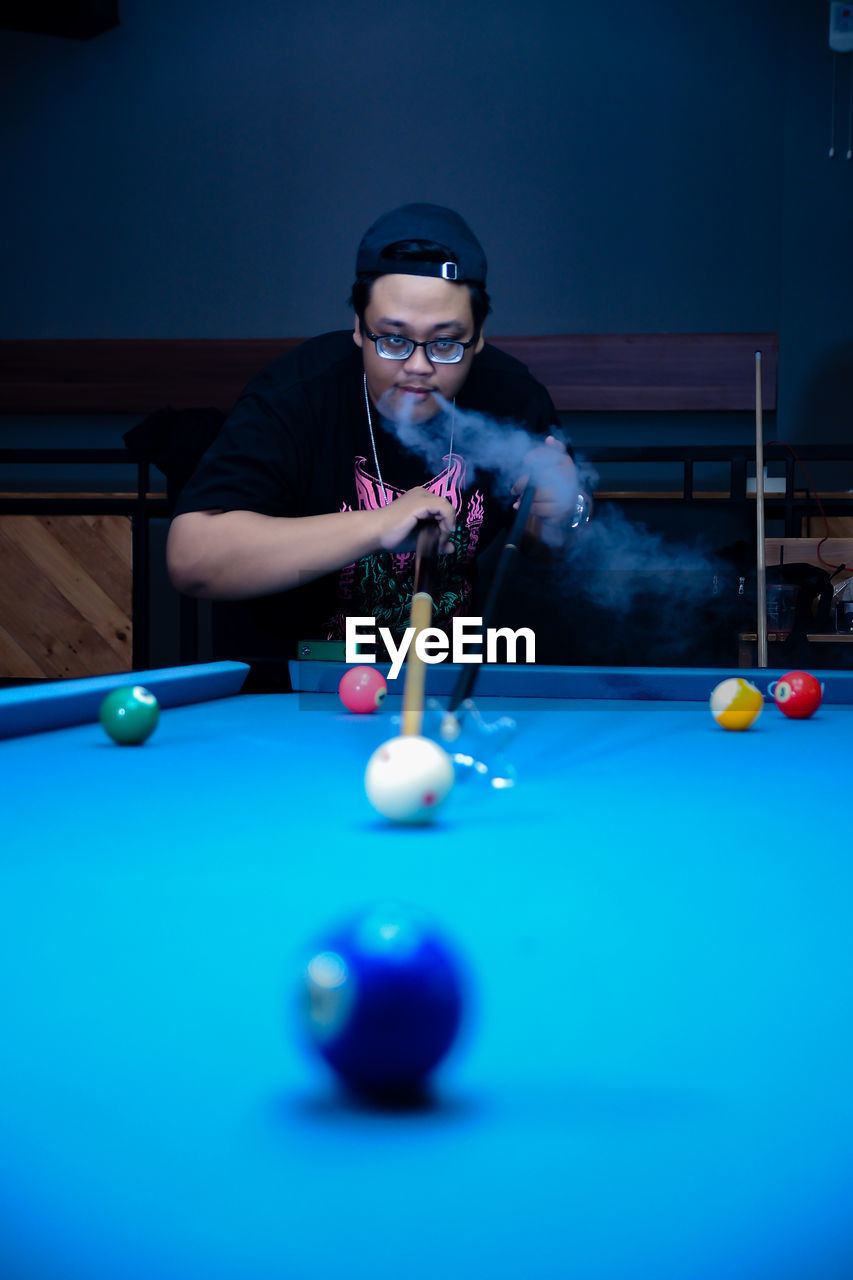 midsection of man playing pool at home