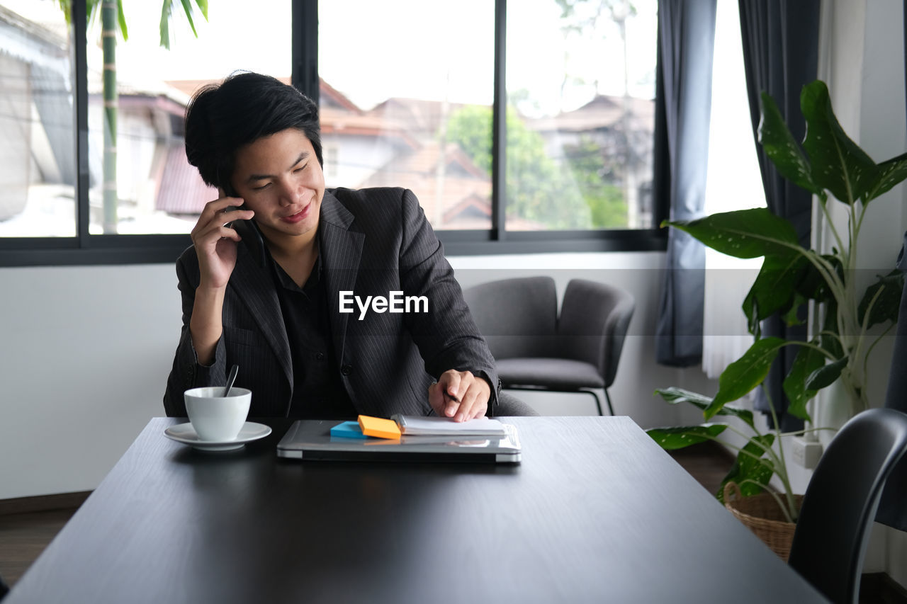 Man talking on phone while sitting in office