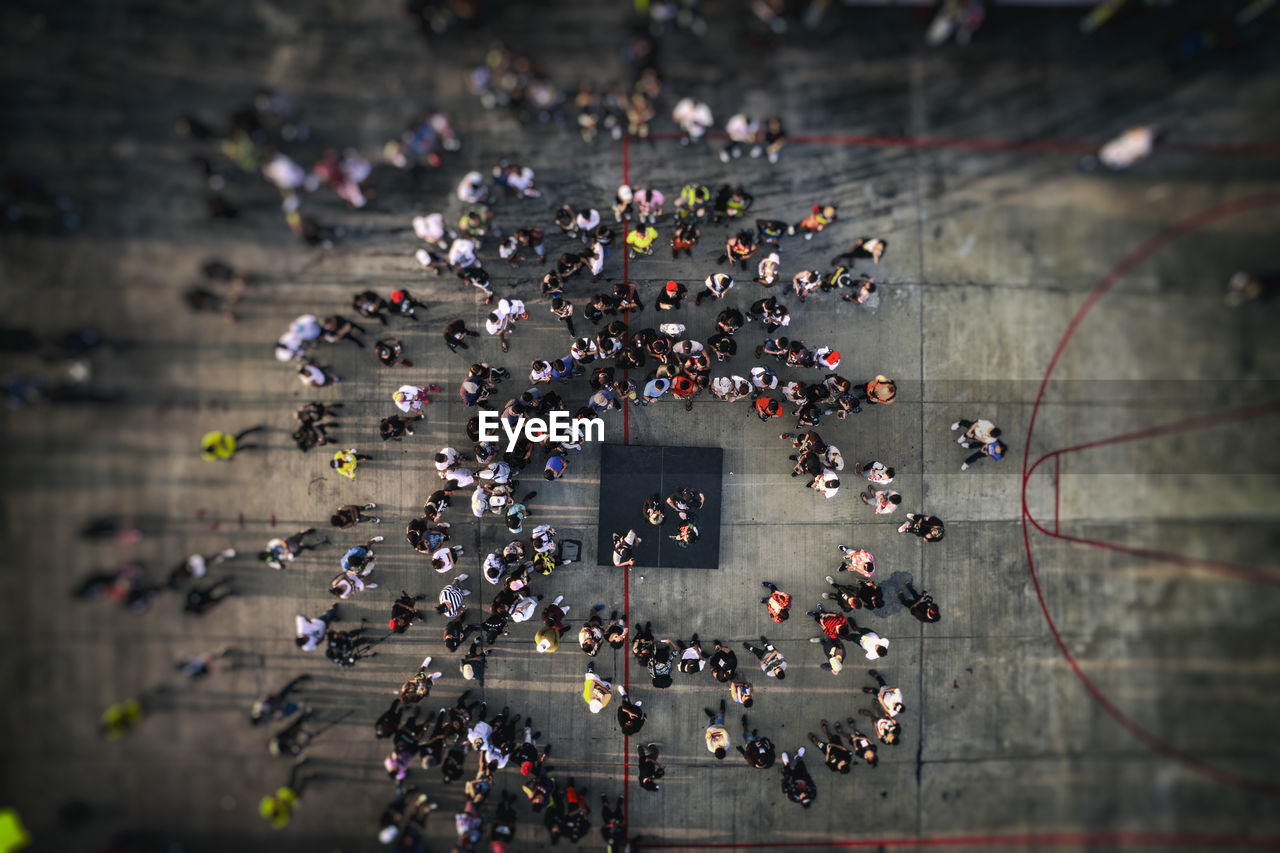 Drone, high angle view from above of people gathering, walking on city street