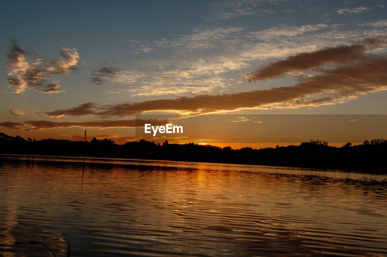 SCENIC VIEW OF LAKE AT SUNSET