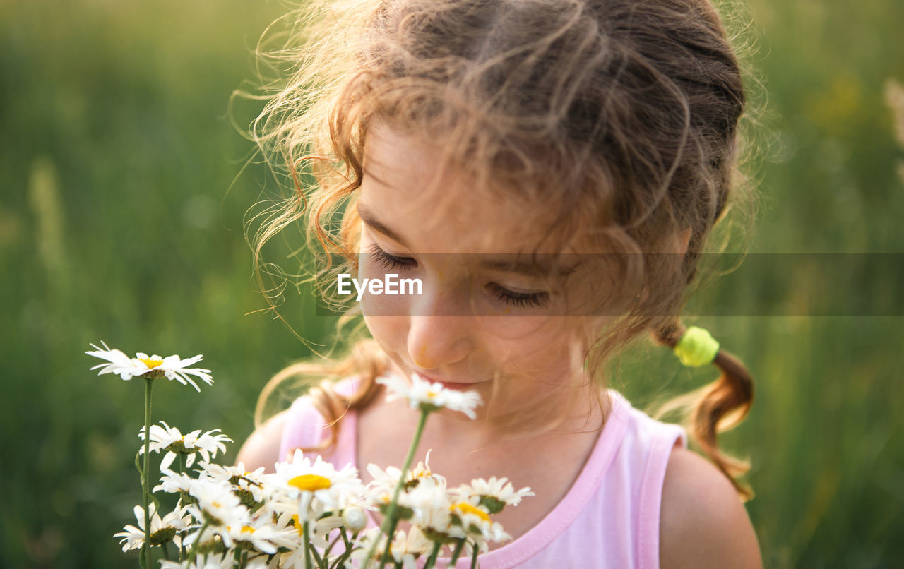 Cute girl smelling flowers