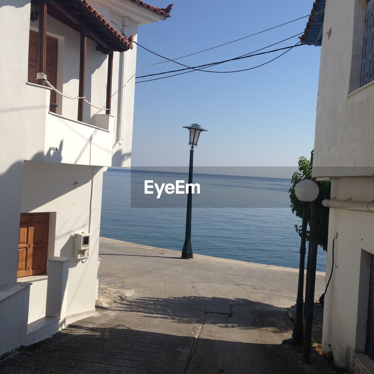 Houses by sea against sky