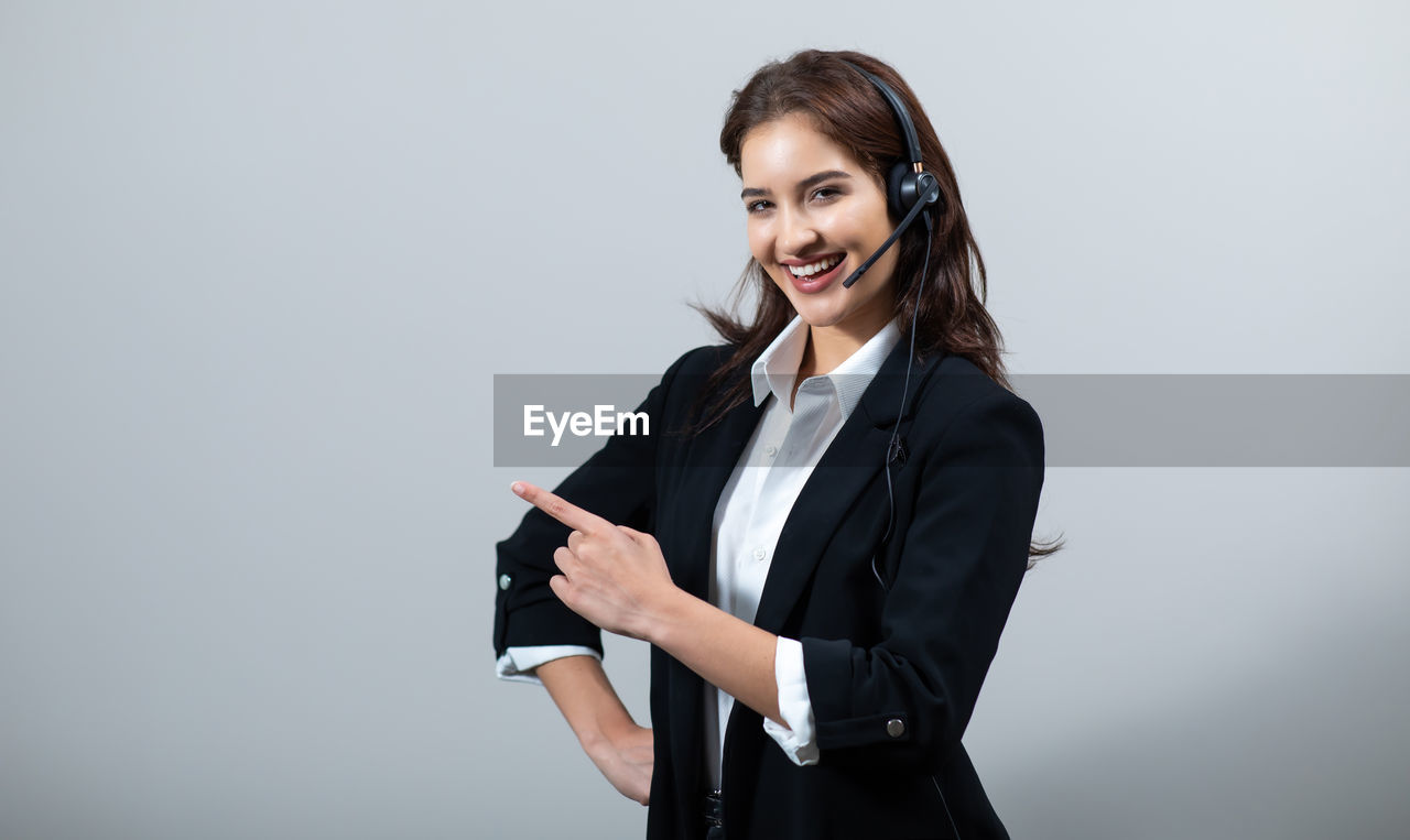 PORTRAIT OF A SMILING YOUNG WOMAN HOLDING CAMERA