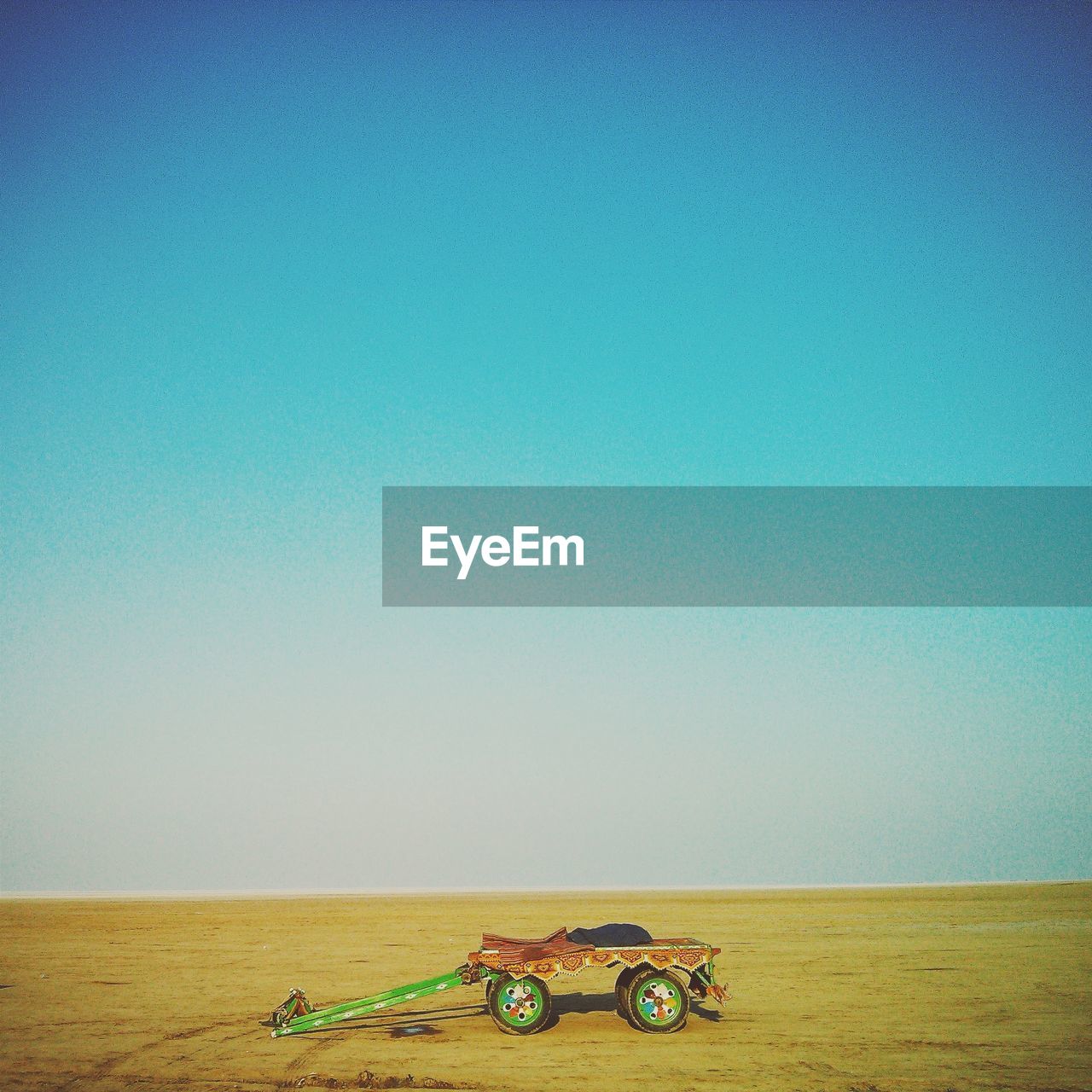 Wagon wheel on field against clear sky