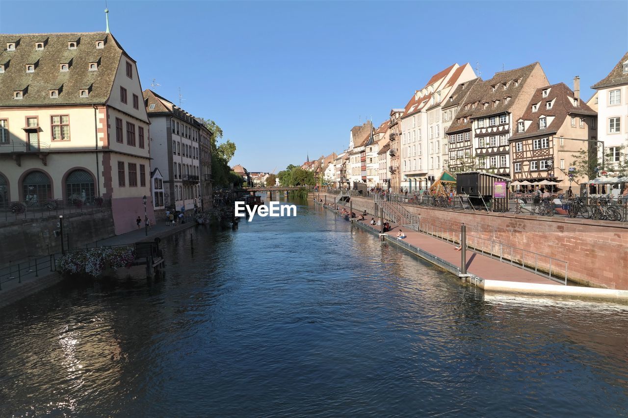 Canal amidst buildings against sky in city