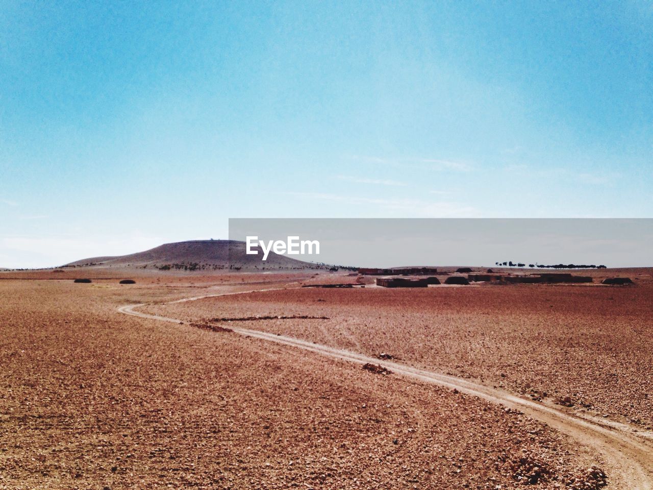 View of desert landscape against blue sky