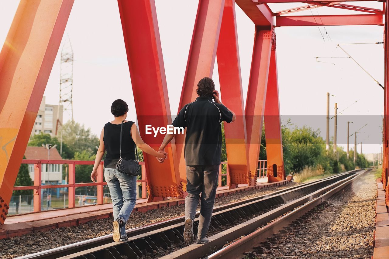 Rear view of people on railroad tracks