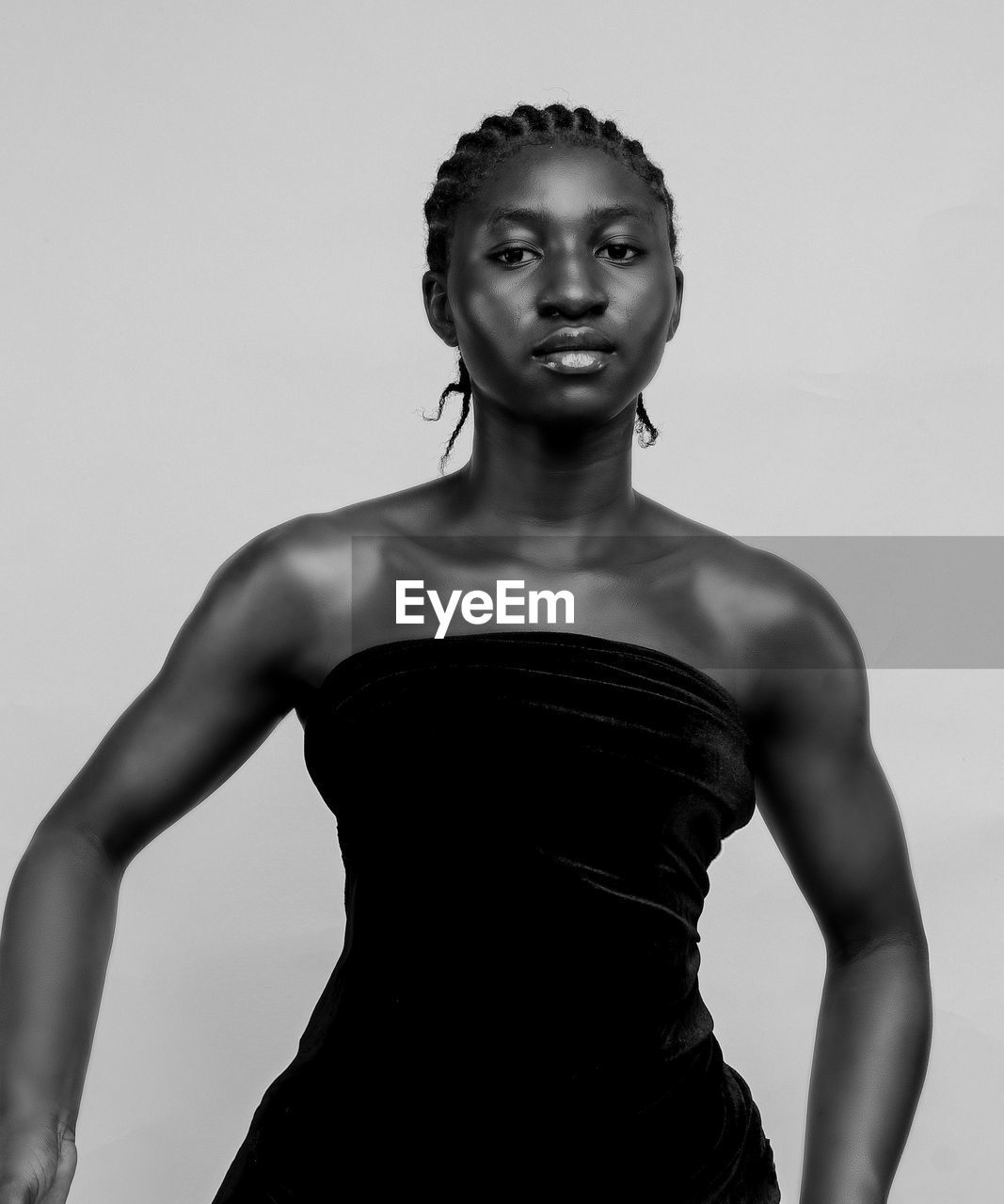 Portrait of young woman standing against white background