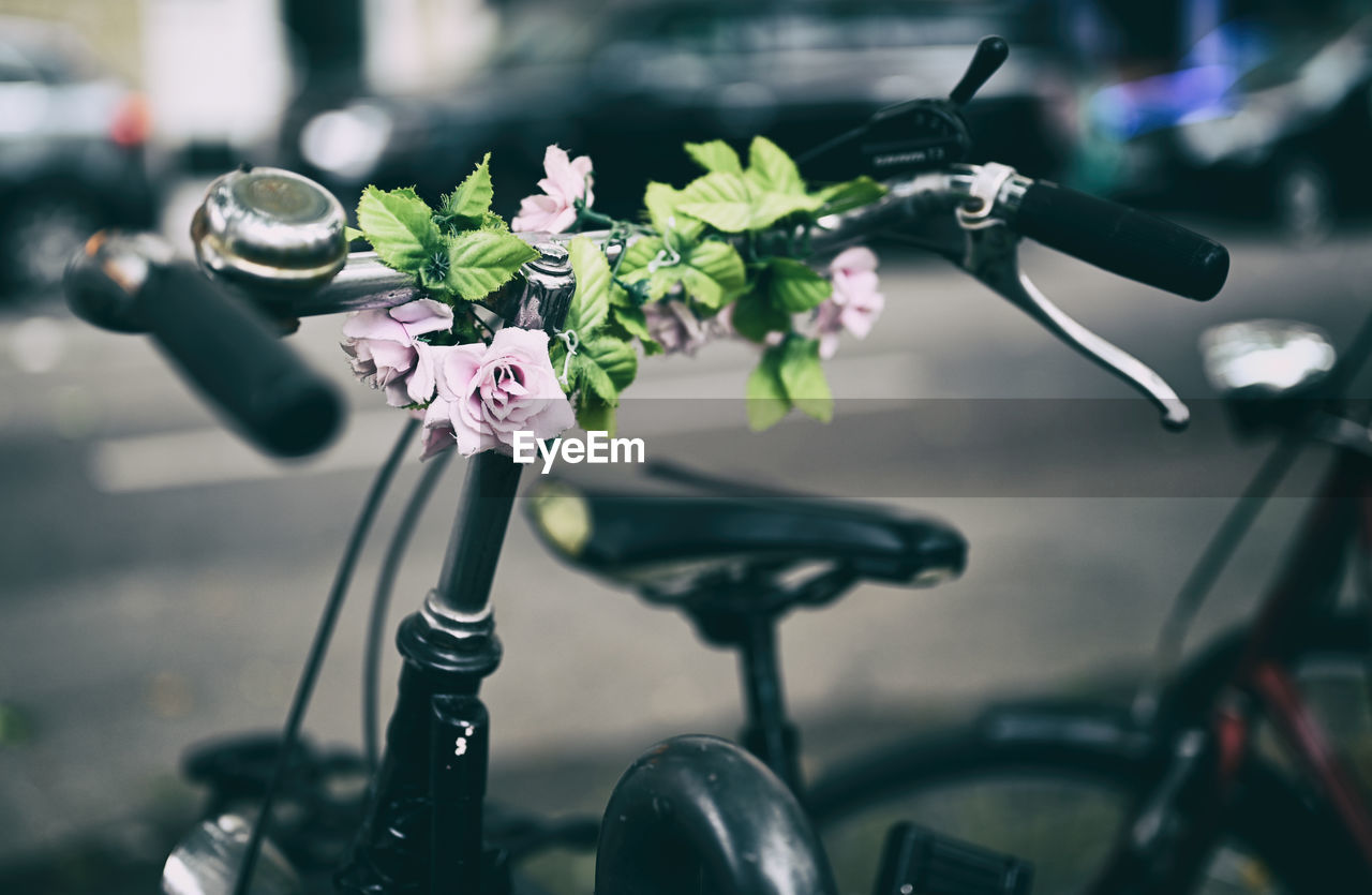 Close-up of bicycle handlebar with flowers